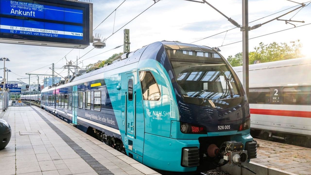 Türkisfarbener NAH.SH-Nahverkehrszug am Bahnsteig